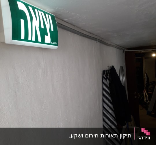 שלט יציאה מואר על קיר לבן